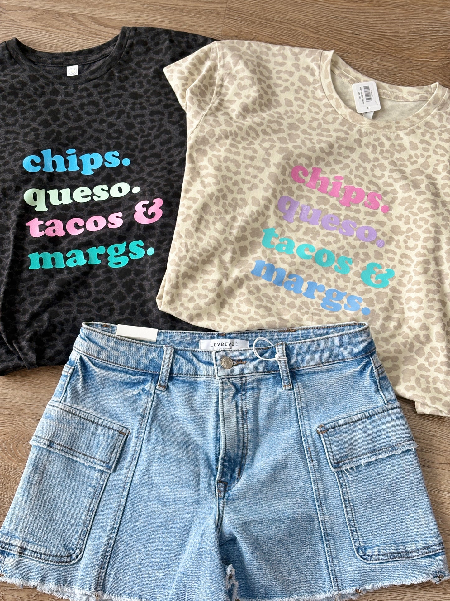 Soft, relaxed-fit cotton tees with fun, colorful Chips Queso Tacos & Margs lettering paired with classic denim shorts. Elle Boutique, Zachary, LA.