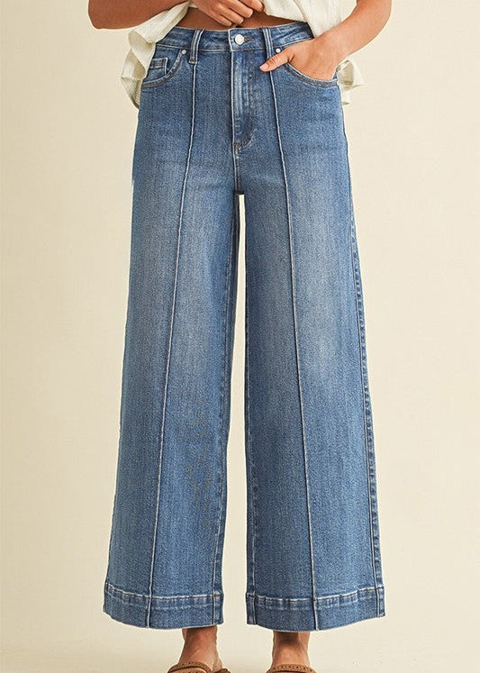 Cozy up in comfy stretch denim wide leg jeans with cute front seams and cuffs, plus a white top and brown sandals. Elle Boutique, Zachary, LA.