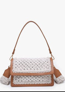 Charming brown vegan leather bag with white crochet, top handle, flap closure, & removable strap. Elle Boutique, Zachary, LA.