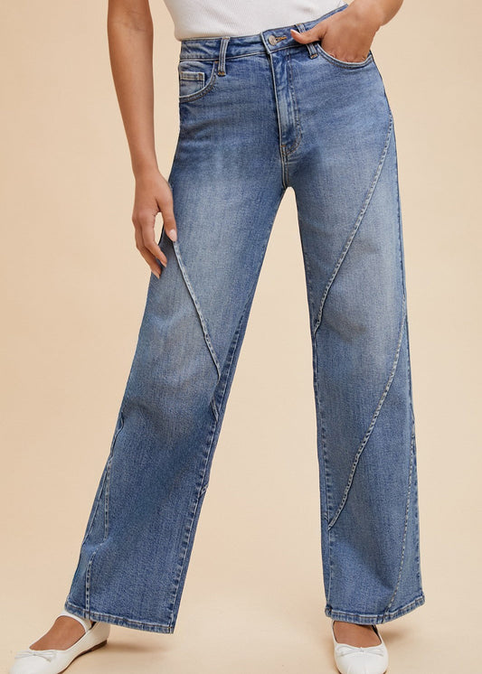 Step into Southern charm with our “Wide Open Spaces - Wide Leg Jeans,” made from soft, comfort stretch denim and finished with darling diagonal seam accents. These relaxed wide-leg jeans pair sweetly with a crisp white sleeveless top and matching white ballet flats, set against a soft beige backdrop. Elle Boutique, Zachary, LA.