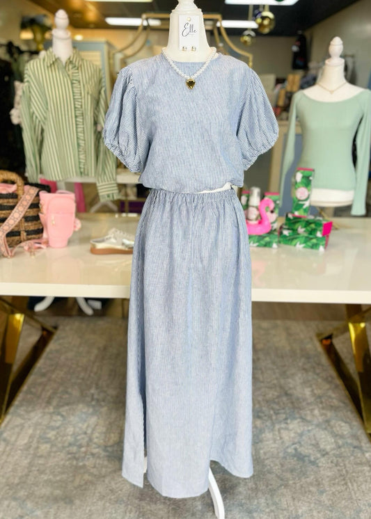 A mannequin wears our Coastal Breeze Set—light blue and white striped cotton, puff sleeve crop top, flowy maxi skirt. Elle Boutique, Zachary, LA.