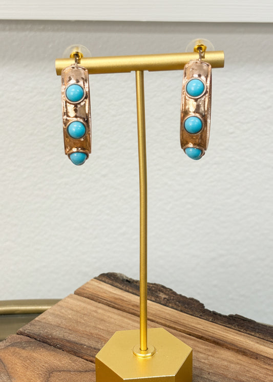 Charming gold hoops with three turquoise stones on each, displayed on a wood stand. Elle Boutique, Zachary, LA.