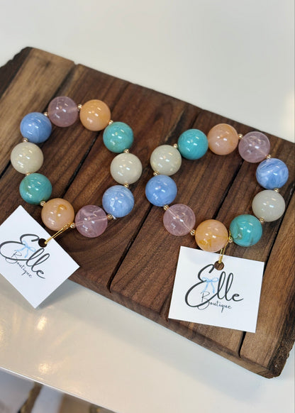 Sweet pastel seed beads in blue, pink, green, white & peach form heart-shaped bracelets with comfy stretch fit. Elle Boutique, Zachary, LA.