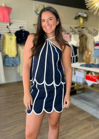 A cheerful lady shows off our comfy navy scalloped set with crisp white trim, perfect for summer days. Elle Boutique, Zachary, LA.