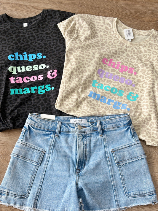 Soft, relaxed-fit cotton tees with fun, colorful Chips Queso Tacos & Margs lettering paired with classic denim shorts. Elle Boutique, Zachary, LA.