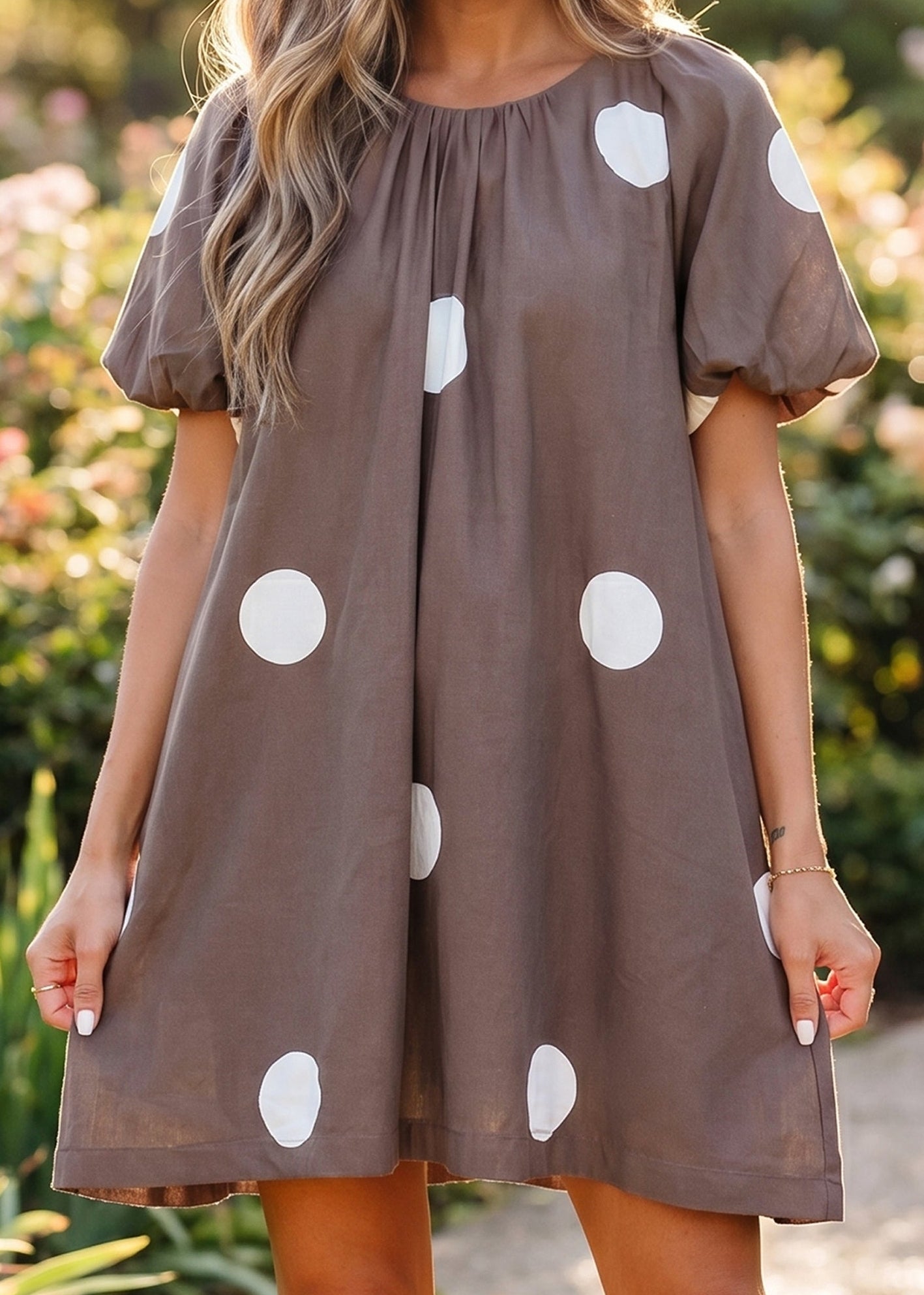 Soak up summer in this breezy cotton-blend brown polka dot mini dress with puff sleeves and knot-back. Elle Boutique, Zachary, LA.