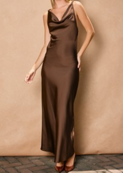 A lovely lady is pictured in the After Hours Satin Maxi Dress, featuring buttery-soft, chocolate brown satin that drapes gracefully to the floor. This sleeveless dress highlights a charming cowl neckline and flows with an easy, relaxed fit—perfect for celebrating love at a fall wedding. The warm hue and elegant silhouette make it a go-to for stylish Southern gatherings. Elle Boutique, Zachary, LA.